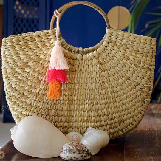 hand woven basket with orange pink and red tassels