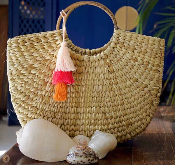 hand woven basket with orange pink and red tassels
