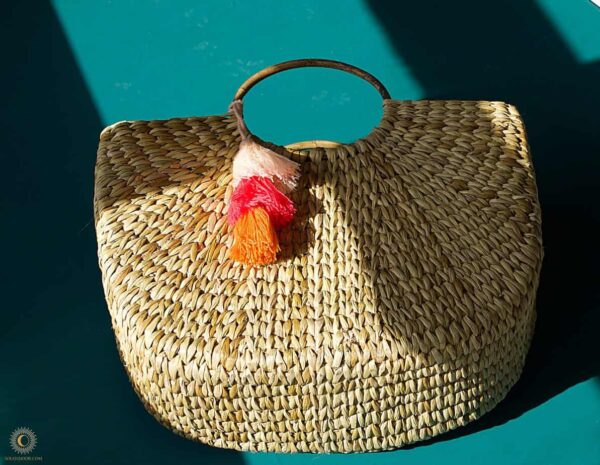 hand woven basket with pink orange and pink tassels