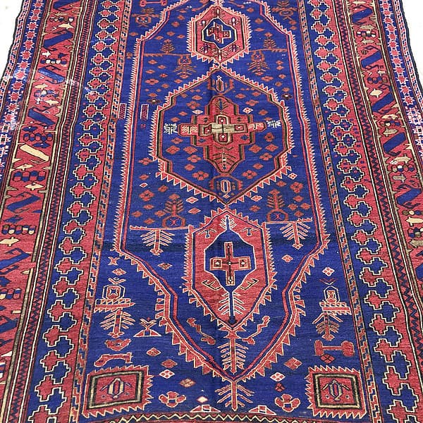 Balouchi Rug made in Afghanistan by kilim has vibrant blue red and browns the photo shows a close up of a vibrant kilim rug