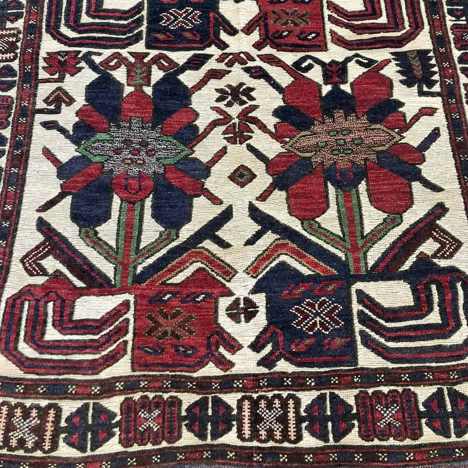 Afghani Rug that has a cream base and colourful tribal repeating patterns.