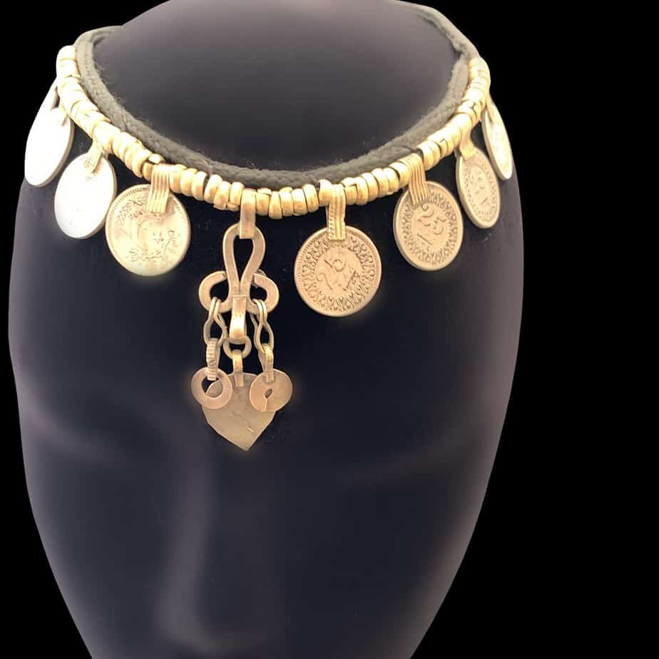 Afghani Antique Choker Necklace, the choker has coins and s spear drop, it is displayed on a mannequin. The necklace is silver in colour
