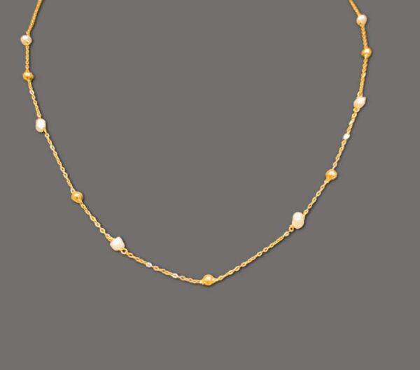 Gold chain that contains gold spheres. Modern style gold and pearl necklace.