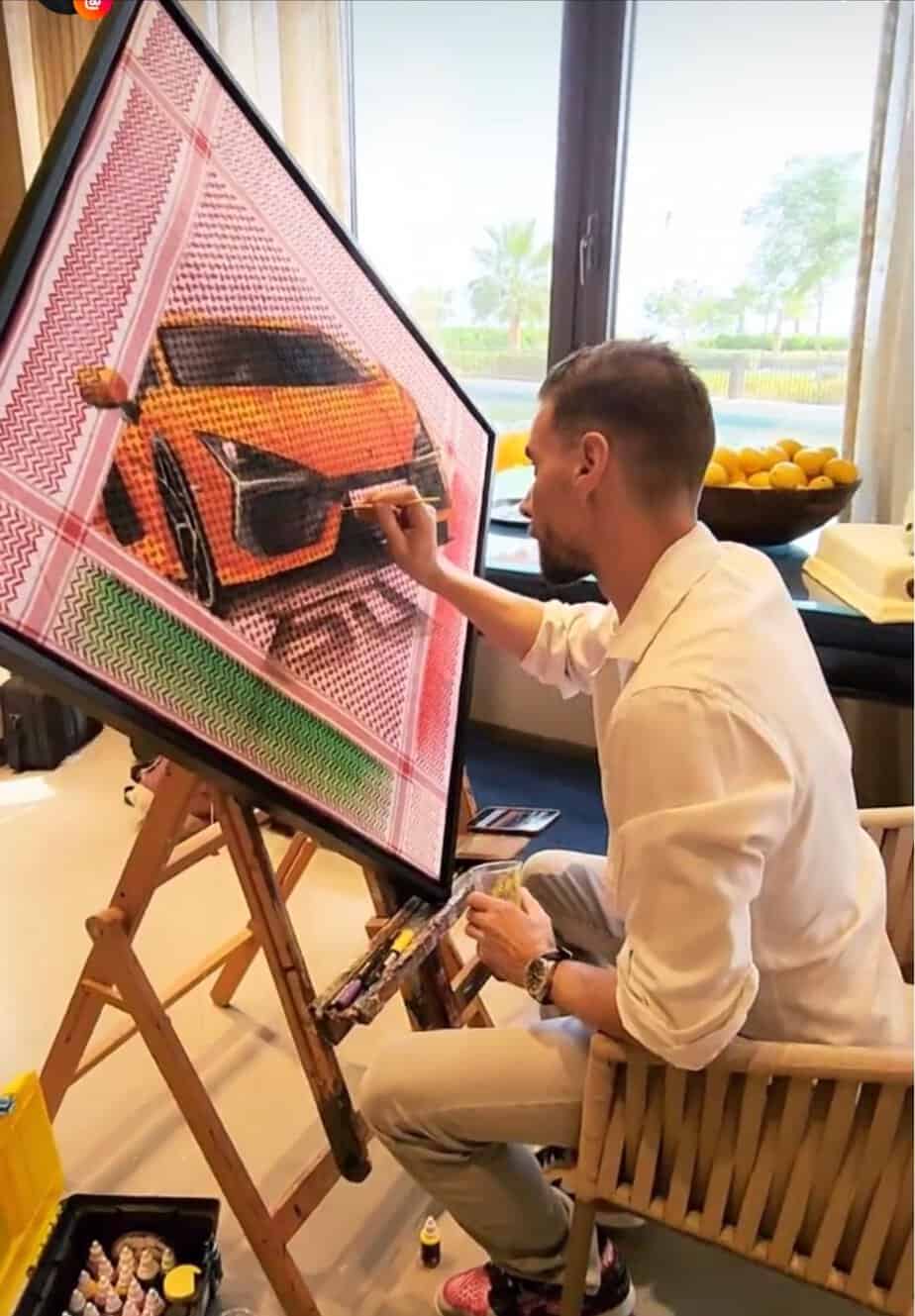 Creative car painting on canvas by an artist in a bright indoor setting.