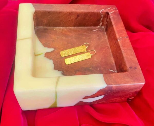 Luxurious marble and onyx jewellery holder with gold earrings for elegant display.