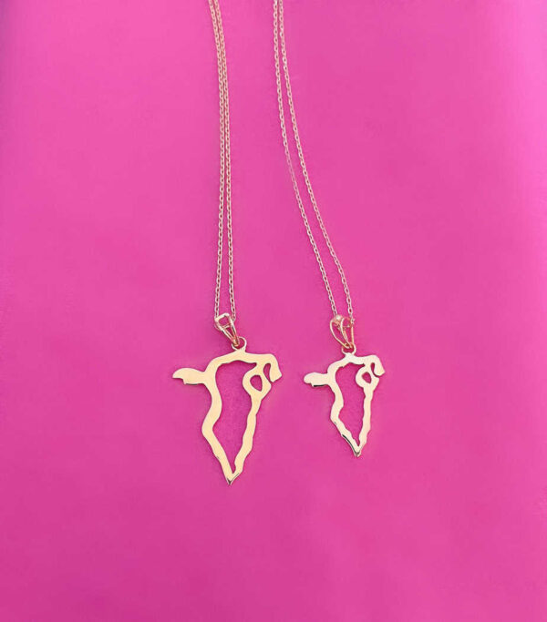 Gold-plated Egypt map necklace pendant on a pink background, featuring two necklaces with Egypt-shaped charms. Perfect for Egyptian-themed accessories and gift ideas.