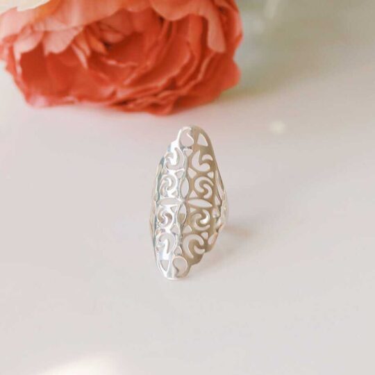 Long beautiful silver ring runs the length of the knuckle with delicate carved cut outs. This is a very unique silver ring.