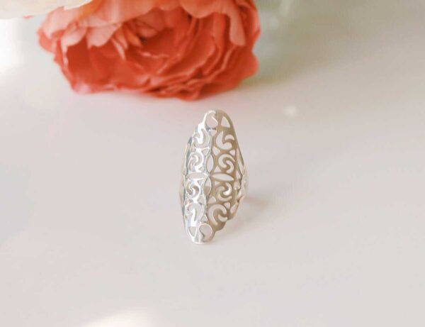 Elegant white filigree ring with intricate swirling design, perfect for women and girls seeking stylish accessories. Ideal for special occasions or everyday wear.