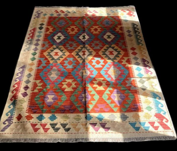 Colorful geometric patterned Moroccan rug with vibrant reds, blues, and greens, ideal for home decoration and adding cultural elegance.