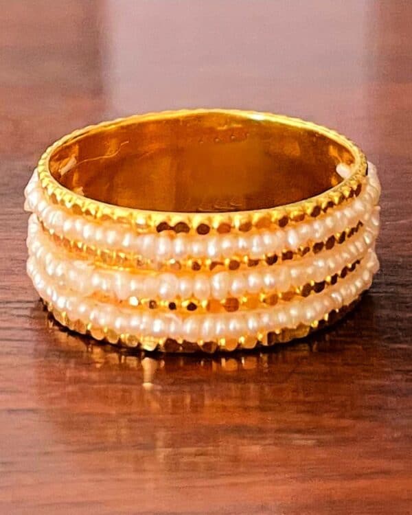 A gold ring with 3 layers of natural pearls