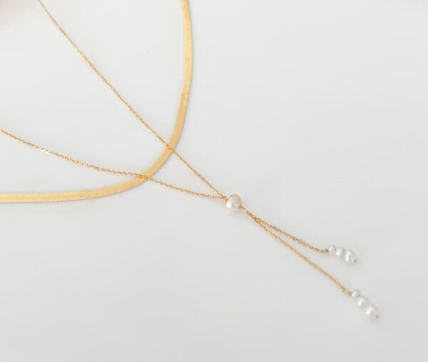 Delicate gold layered necklace with natural pearl accents, elegant jewellery accessory for women, perfect for everyday or special occasions.