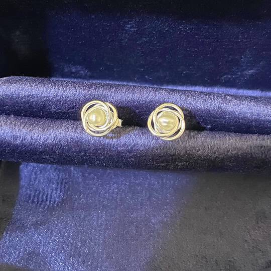 Elegant pearl and silver stud earrings displayed on a dark satin fabric, ideal for jewellery collections and fashion accessories. Perfect gift for special occasions and stylish outfits. The pearls are natural pearls from Bahrain Waters.