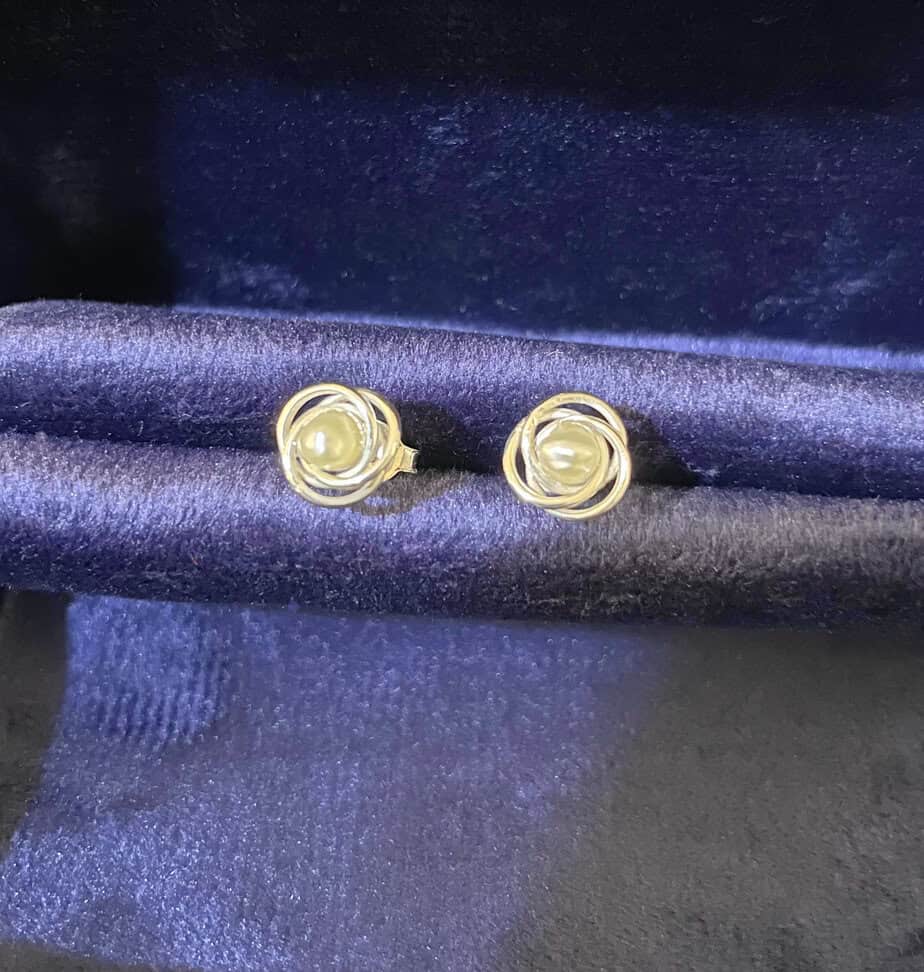 Elegant pearl and silver stud earrings displayed on a dark satin fabric, ideal for jewellery collections and fashion accessories. Perfect gift for special occasions and stylish outfits. The pearls are natural pearls from Bahrain Waters.