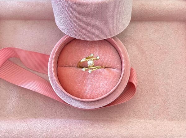 Beautiful gold ring with pearl and diamond accents displayed in a pink velvet ring box, ideal for gifting or special occasions, highlighting luxury jewellery from Souq2Door.