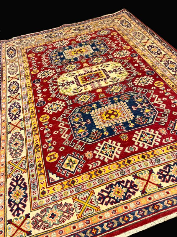 A colourful, detailed Kazak Oriental rug featuring traditional geometric designs, ideal for enhancing elegance in living rooms or entryways. This is a hand knotted rug featuring traditional tribal motifs from Afghanistan that include medallions, stars and crosses.