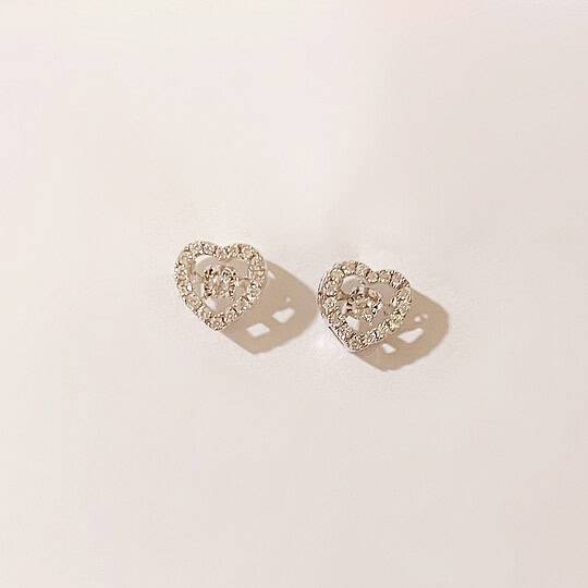 Delicate heart-shaped earrings adorned with diamonds, made in white gold, perfect for fashionable accessories or gifting. Elegant, shiny, and stylish jewellery pieces for women.