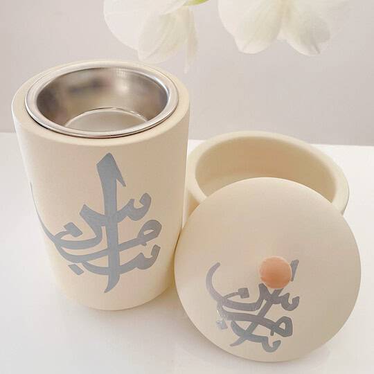 Bahrain Pottery, Bakhoor Burner with Arabic design and stainless steel interior to burn oud. The pottery is cream with handprinted Arabic Calligraphy.