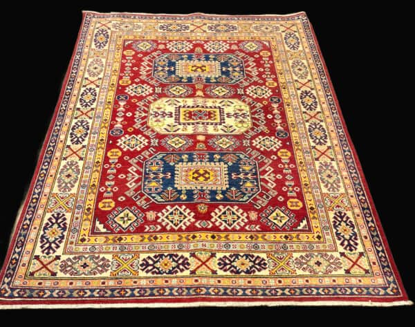 Beautifully crafted oriental rug showcasing detailed geometric patterns, bright colours, and traditional design, ideal for enhancing living room or dining space decor. This is a special hand-knotted Kazak Rug from Afghanistan.