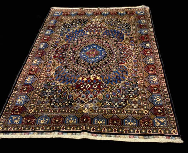 Handknotted Persian Rug in vibrant shades of blue, black, cream and saffron. the handwoven pattern is a traditional fish eye pattern which refers to the scales which represent fish scales which interlock the central medallion.
