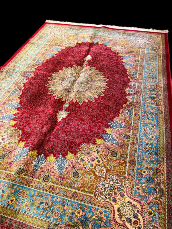 Silk Persian rug featuring detailed floral motifs, rich reds, blues, and golds, perfect for adding elegance to any living space.