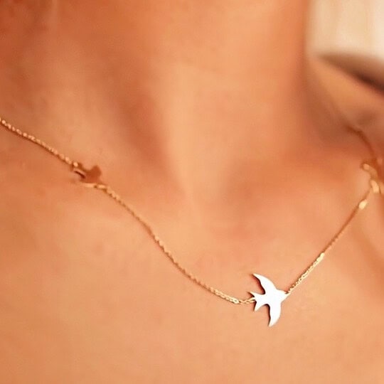 Gold necklace with swallows pendant, ideal for elegant jewelry lovers.