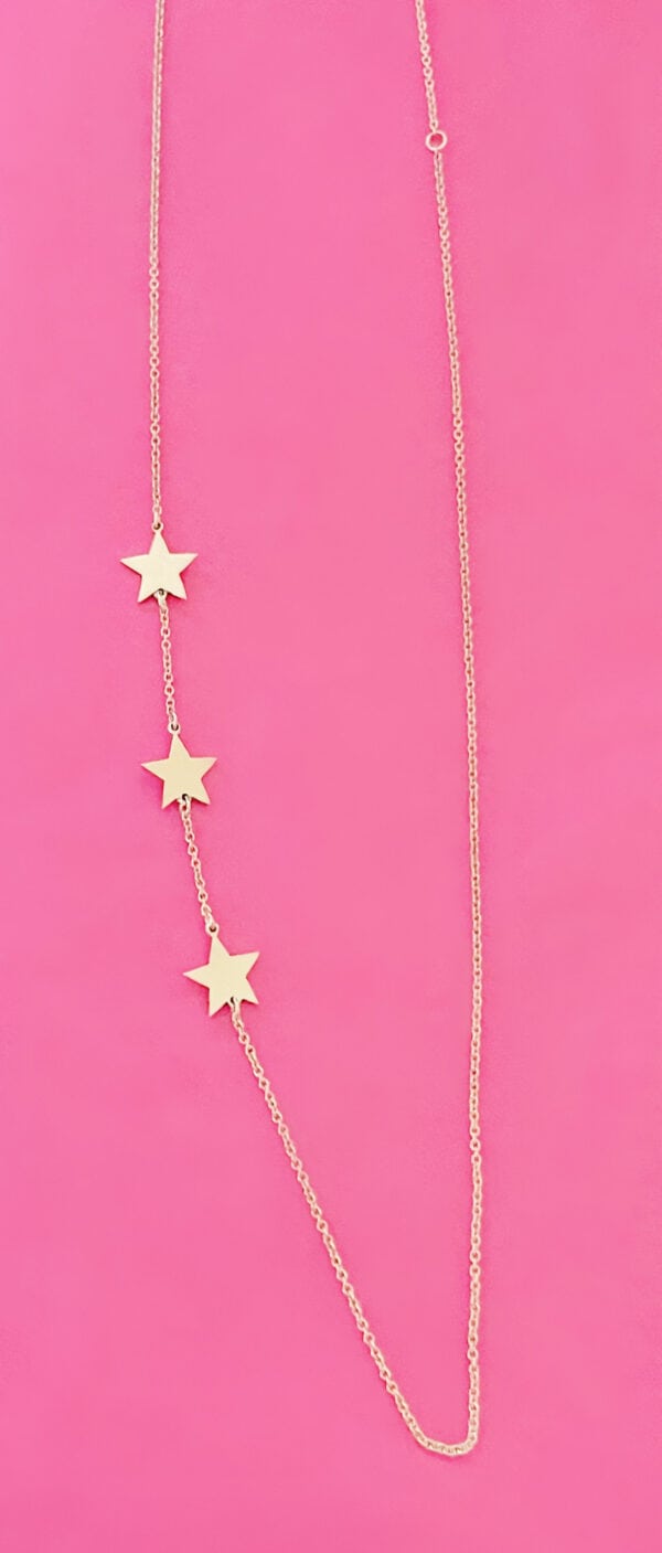 Elegant star pendant necklace with three gold stars on a delicate chain, displayed against a vibrant pink background. Perfect accessory for stylish and trendy outfits.