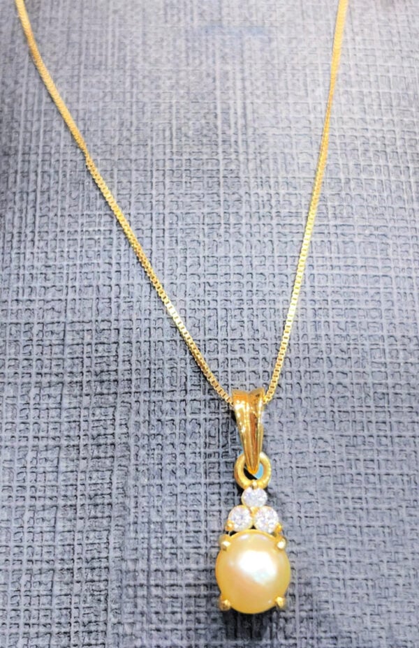 Gold pearl pendant necklace featuring a large, lustrous pearl surrounded by small diamonds on a delicate gold chain.