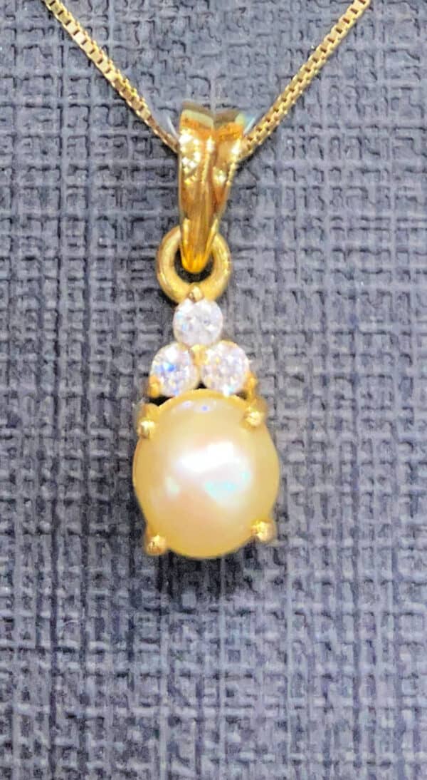 Gold pendant necklace featuring a lustrous pearl and sparkling diamonds, perfect for elegant occasions. Crafted with high-quality materials, this jewellery piece adds sophistication to any outfit.