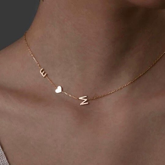 Gold necklace with heart and letter charms, stylish jewelry for women.