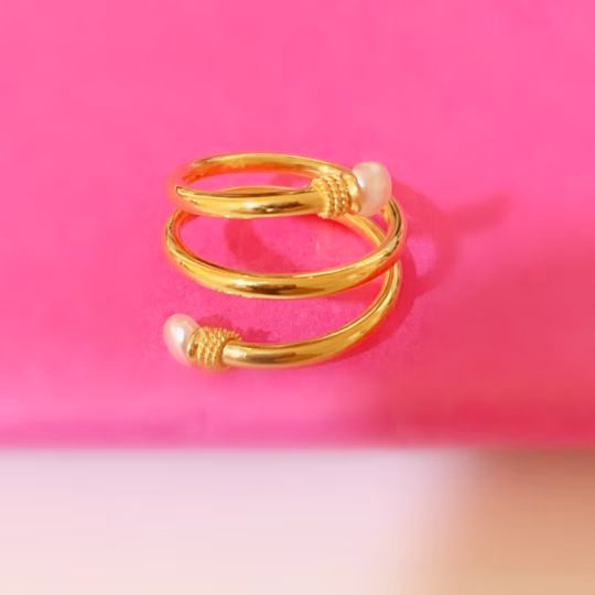 A gold ring with three spirals it contains 2 Bahraini pearls